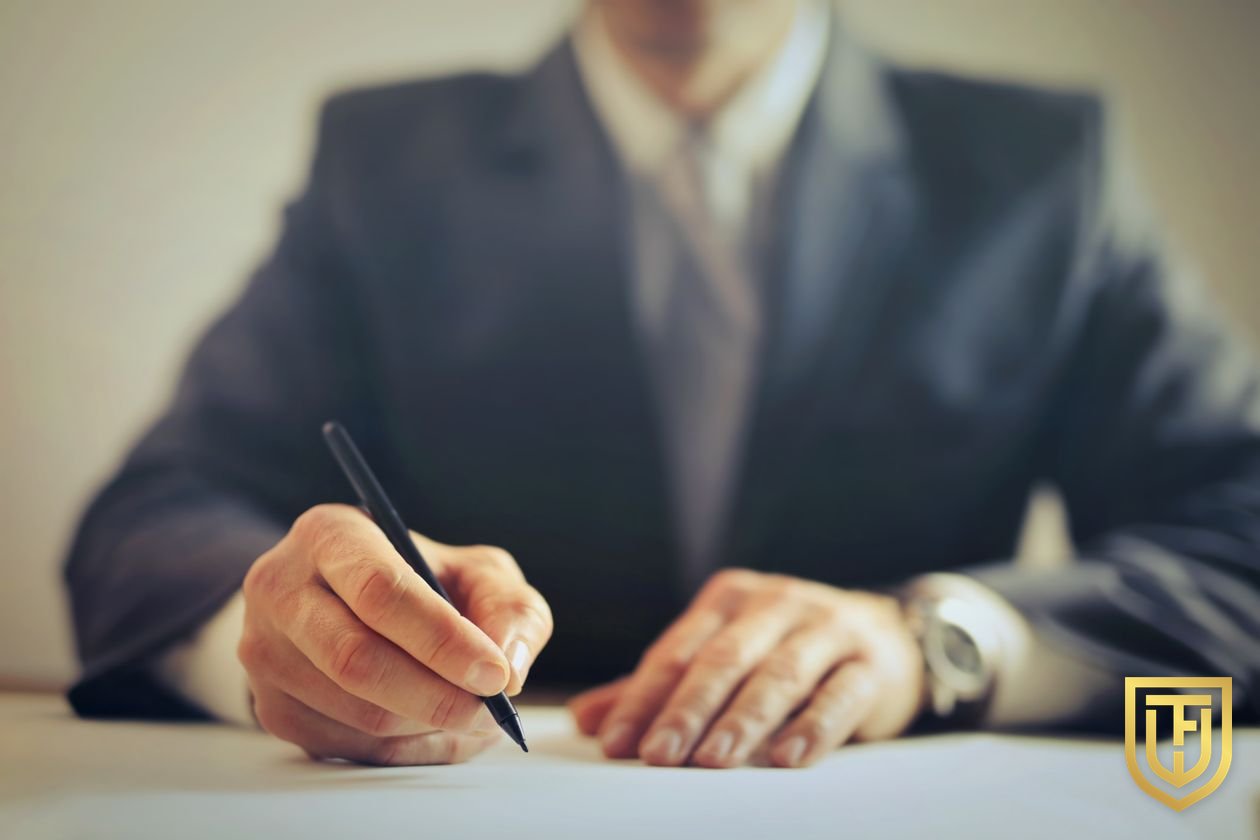 Person at a desk signing a document